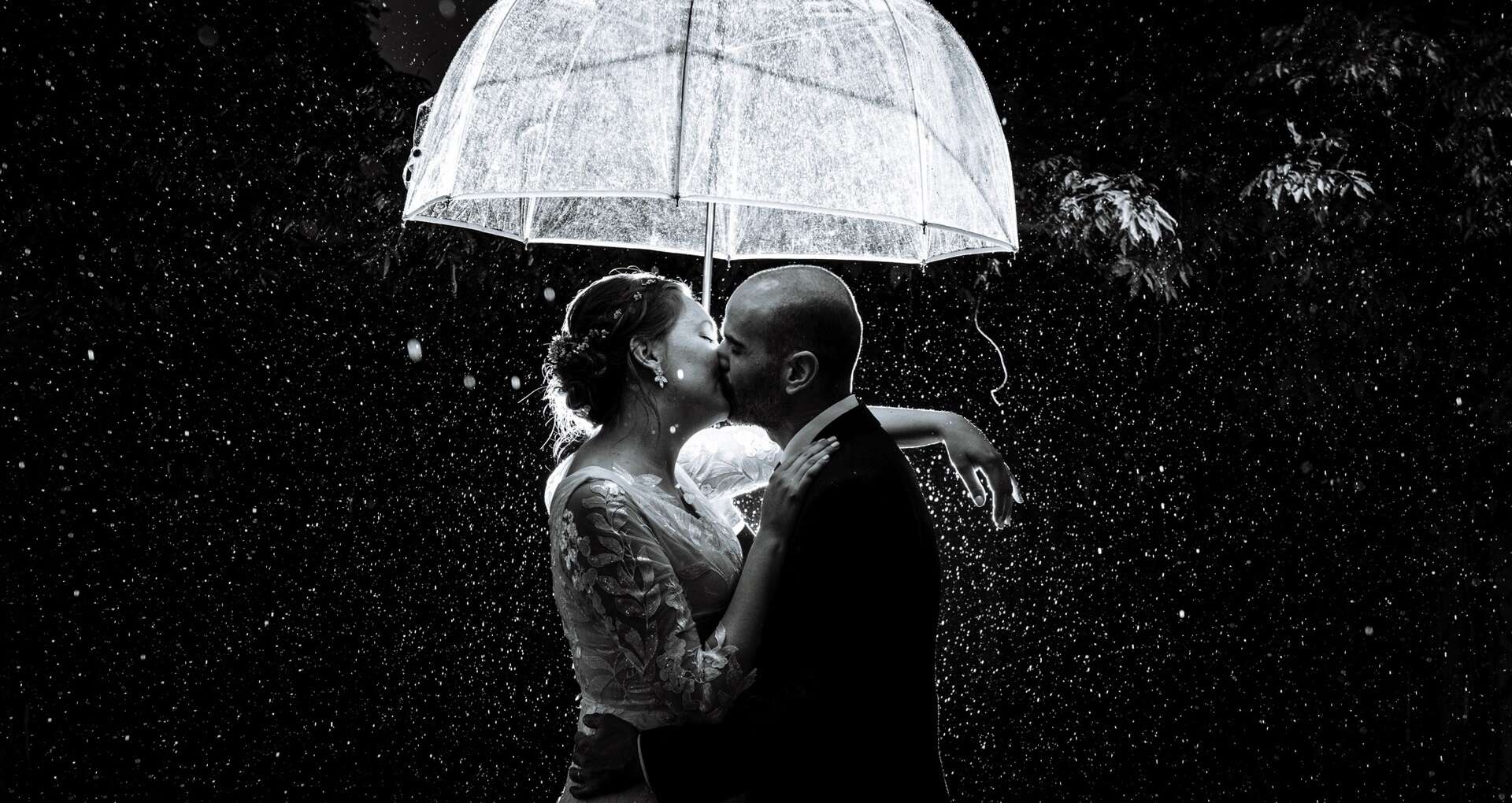 Regenfoto in de avond met bruidspaar