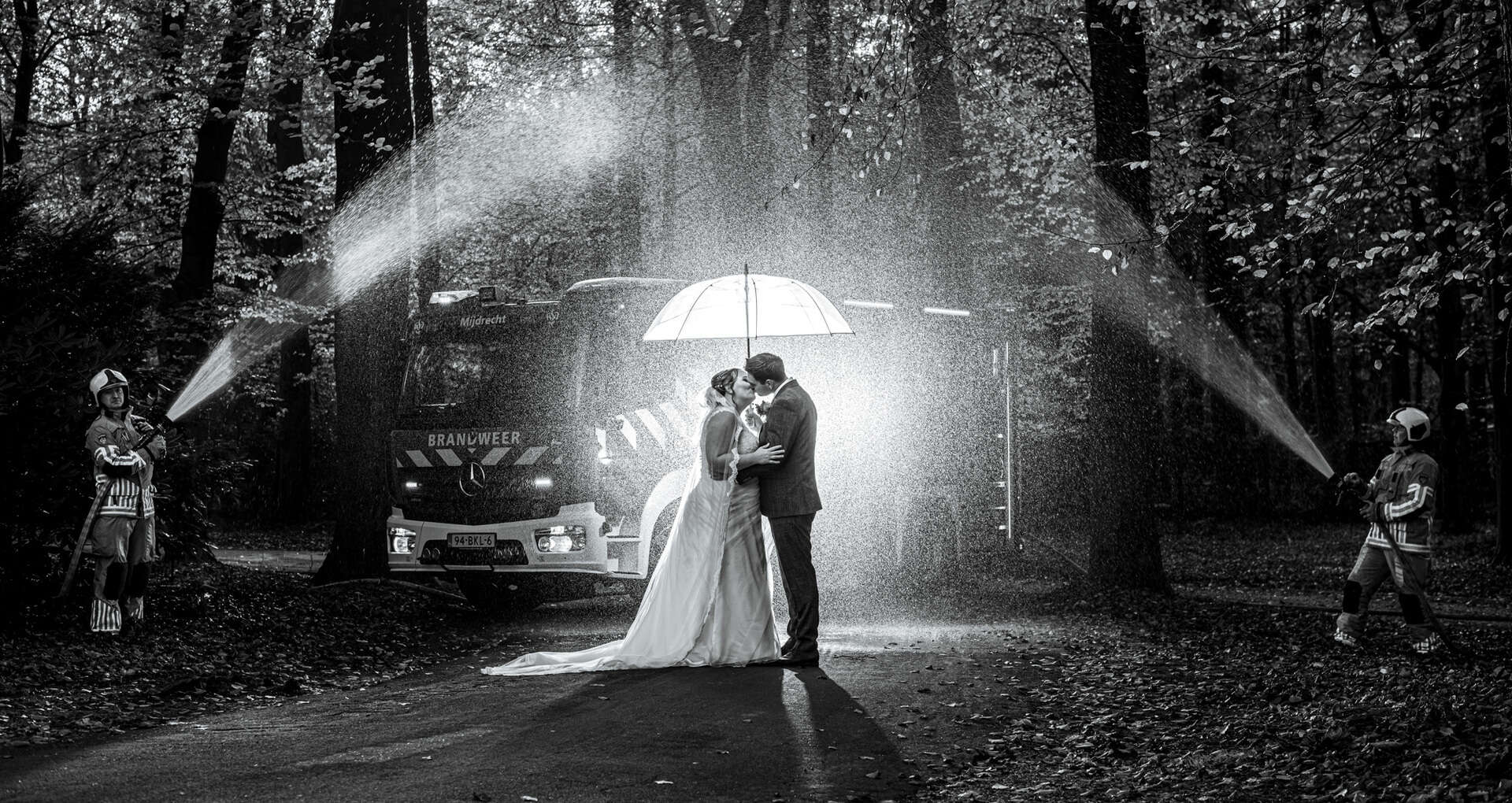 Trouw regenfoto met paraplu en brandweer